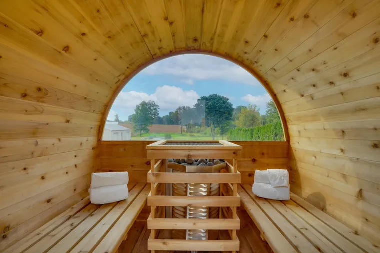 Cedar barrel sauna interior looking out over a green field