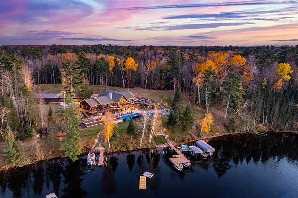 Aerial view of a lakefront lodge estate at dusk
