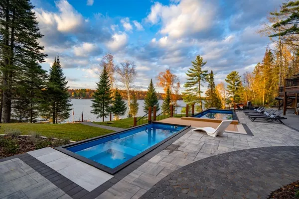 Twin pools overlooking a lake at an estate property
